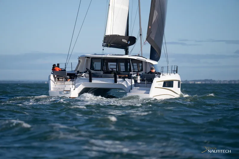 Slide: The Image of 2025 Nautitech 48 Open catamaran sailing on open water, showcasing sleek design and performance. - 12