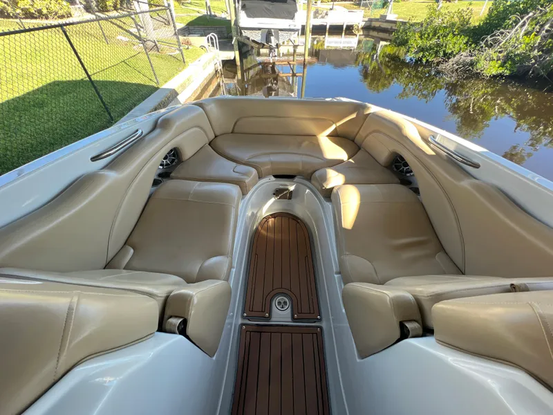 Slide: The Image of 2018 Crownline E26 XS boat interior with tan leather seating and wooden flooring. - 11