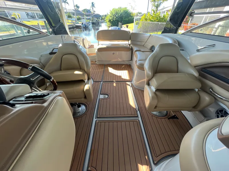 Slide: The Image of 2018 Crownline E26 XS boat interior with tan seating and wood flooring. - 13