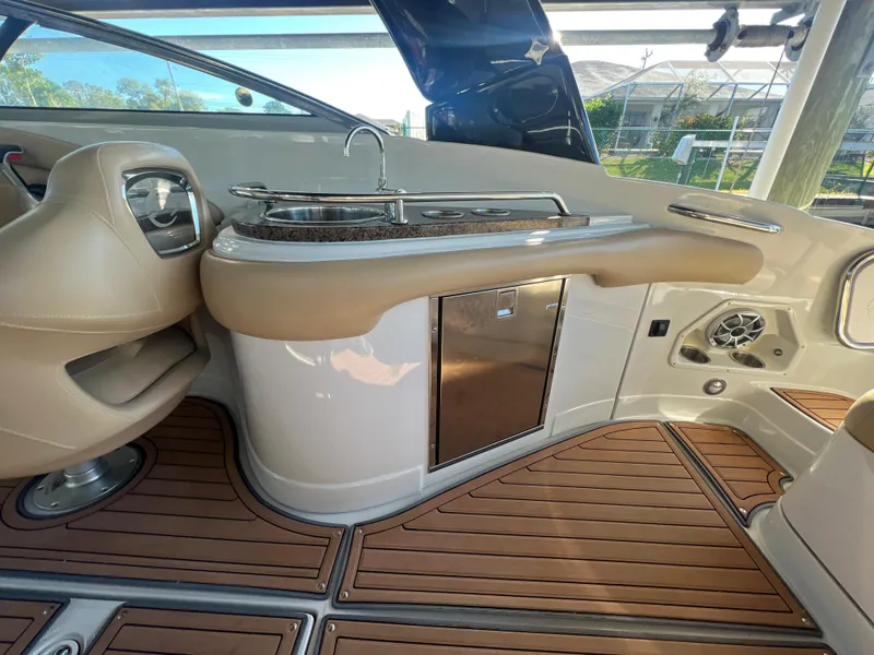 Slide: The Image of 2018 Crownline E26 XS boat interior with sink, storage, and wood flooring. - 16