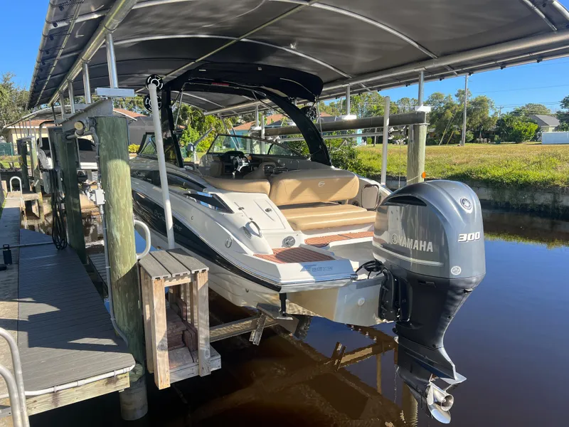 Slide: The Image of 2018 Crownline E26 XS boat with Yamaha 300 engine docked under canopy. - 23