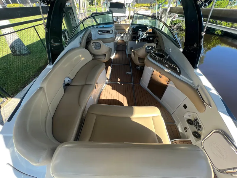 Slide: The Image of 2018 Crownline E26 XS boat interior with beige seating and wood flooring. - 4