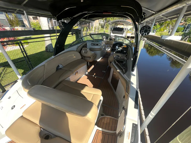 Slide: The Image of 2018 Crownline E26 XS boat interior with tan seating and wood flooring. - 5
