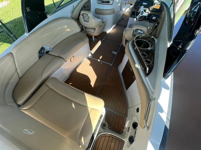 Slide: The Image of 2018 Crownline E26 XS boat interior with tan seating and wood flooring. - 6