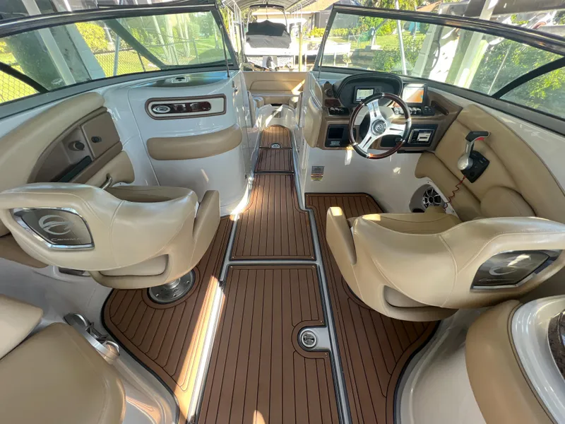 Slide: The Image of 2018 Crownline E26 XS boat interior with beige seating and wood-style flooring. - 7