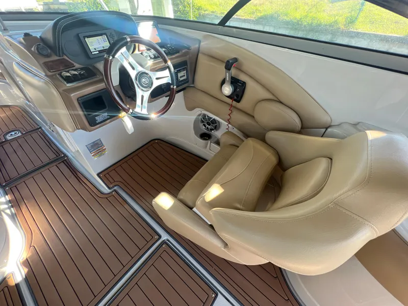 Slide: The Image of 2018 Crownline E26 XS boat interior with beige seating and wood-style flooring. - 9