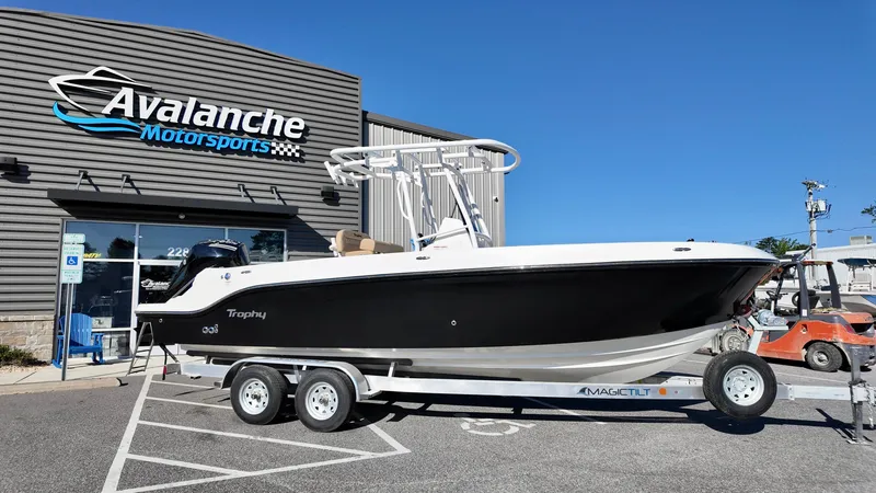 The Image of 2025 Bayliner Trophy 24 CC boat on trailer at Avalanche Motorsports dealership. - 0