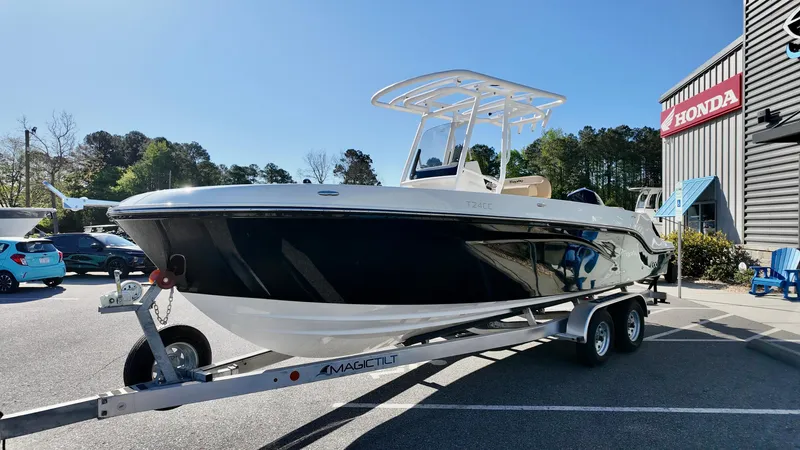 Slide: The Image of 2025 Bayliner Trophy 24 CC boat on trailer, parked outside dealership. - 2