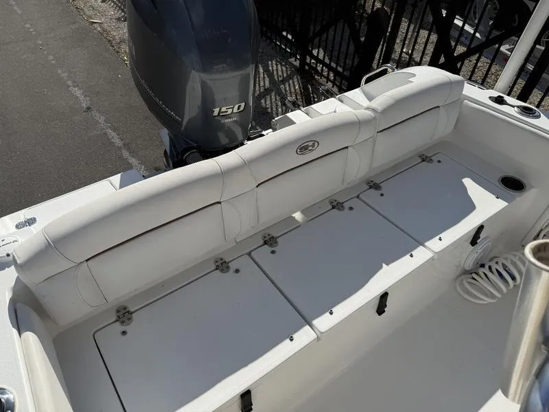 Slide: The Image of 2019 Sea Hunt Ultra 211 boat with white seating and 150 horsepower engine. - 13