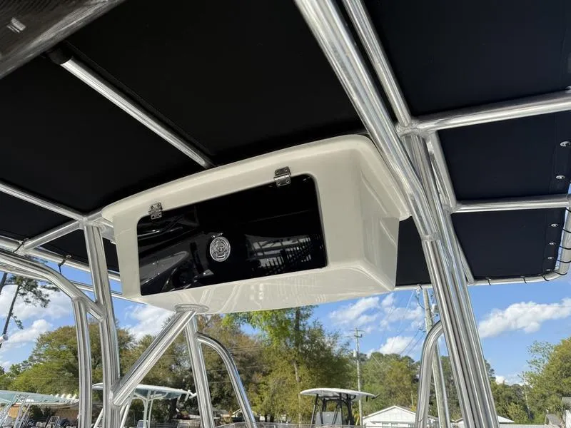 Slide: The Image of 2019 Sea Hunt Ultra 211 T-top with storage compartment, under a clear blue sky. - 8