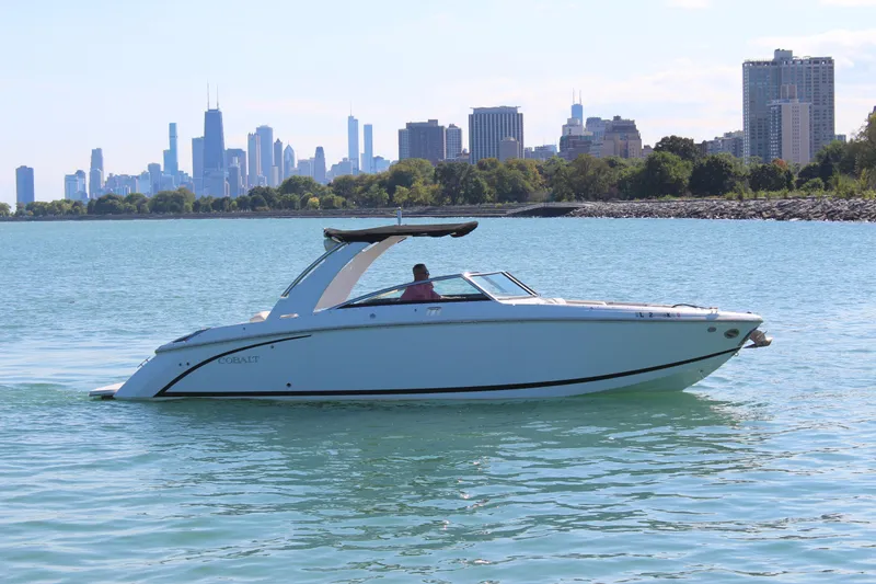 Slide: The Image of 2016 Cobalt R30 boat cruising on a lake with city skyline in the background. - 1