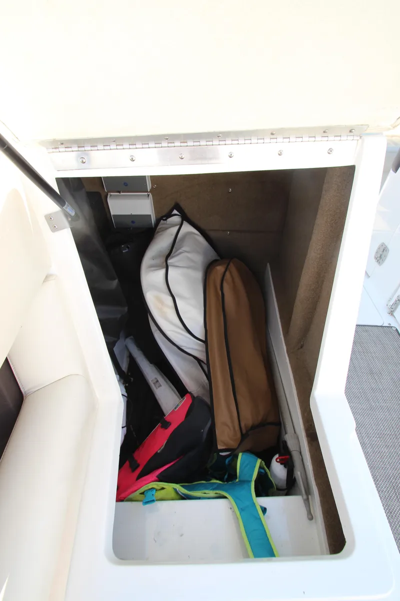 Slide: The Image of Storage compartment in a 2016 Cobalt R30 boat, containing various bags and equipment. - 19