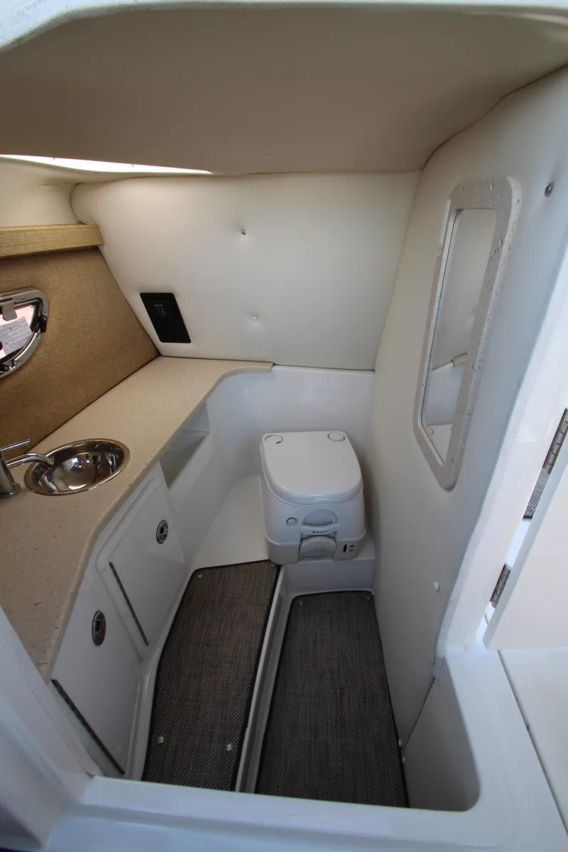 Slide: The Image of 2016 Cobalt R30 boat interior with compact bathroom and sink. - 24