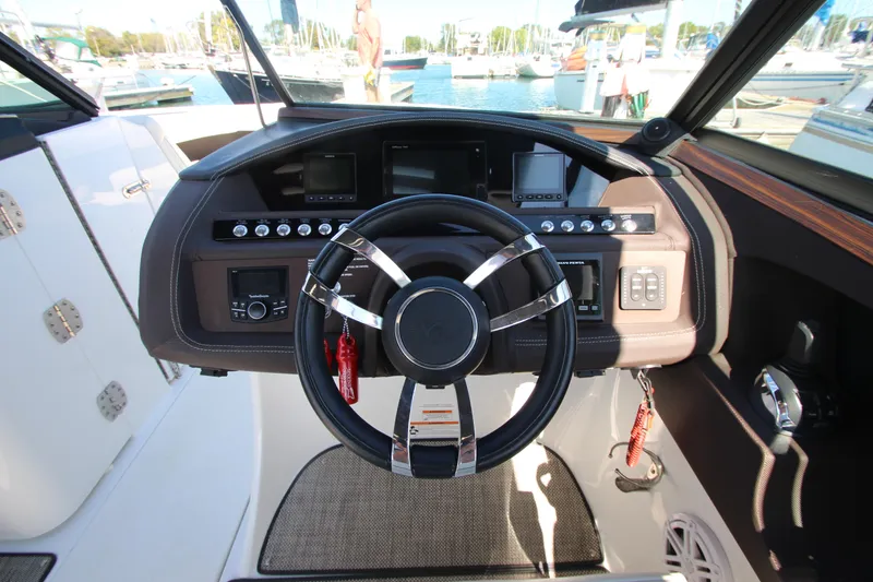 Slide: The Image of 2016 Cobalt R30 boat dashboard with steering wheel and control panel. - 28