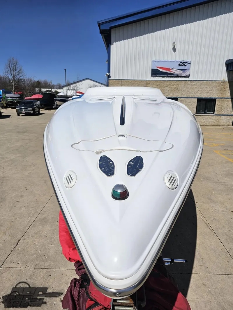 Slide: The Image of 2002 Baja 342 boat, white hull, parked outdoors near a building. - 12