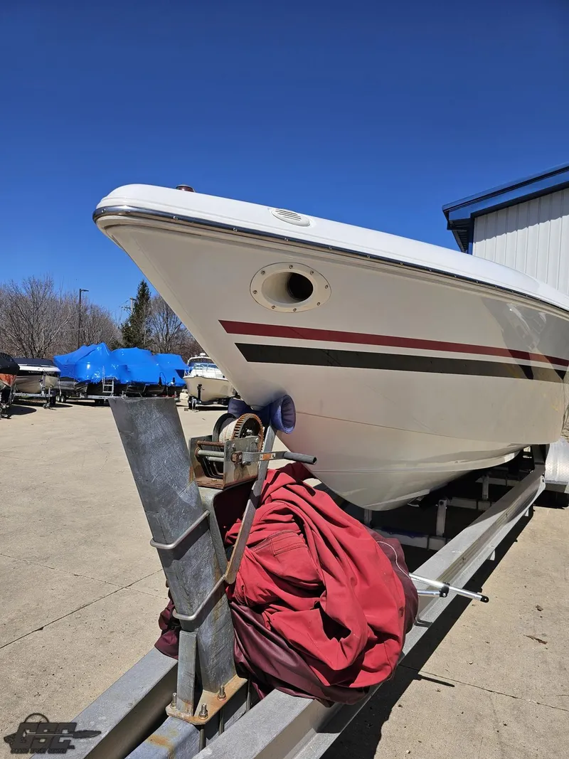 Slide: The Image of 2002 Baja 342 boat on trailer, red cover, clear blue sky background. - 13