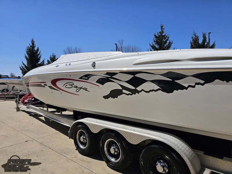 Slide: The Image of 2002 Baja 342 speedboat on trailer, featuring sleek design and checkered flag graphics. - 24