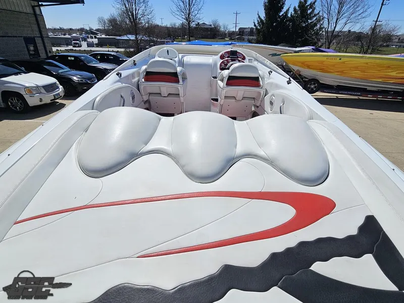 Slide: The Image of 2002 Baja 342 speedboat with sleek white and red interior design, parked outdoors. - 37