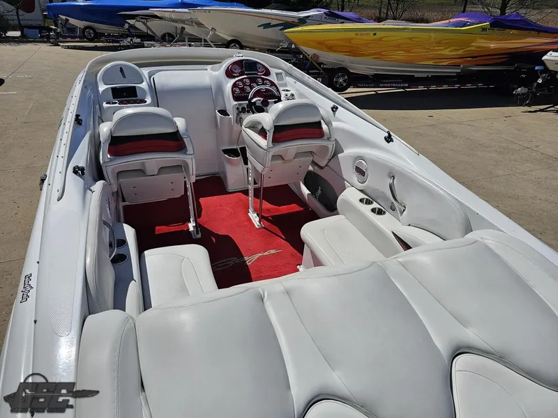 Slide: The Image of 2002 Baja 342 boat interior with white and red seating, docked alongside colorful boats. - 42