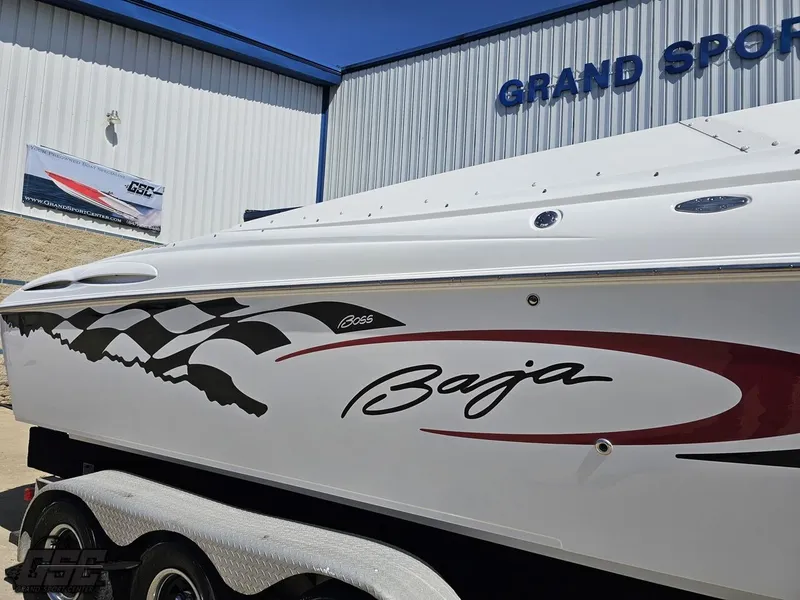 Slide: The Image of 2002 Baja 342 boat with racing graphics, parked at Grand Sport facility. - 7
