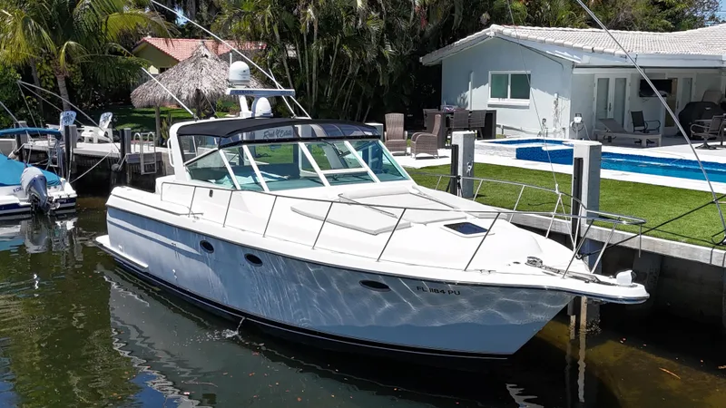 The Image of 1998 Tiara Yachts 3500 Express docked by a waterfront home. - 0
