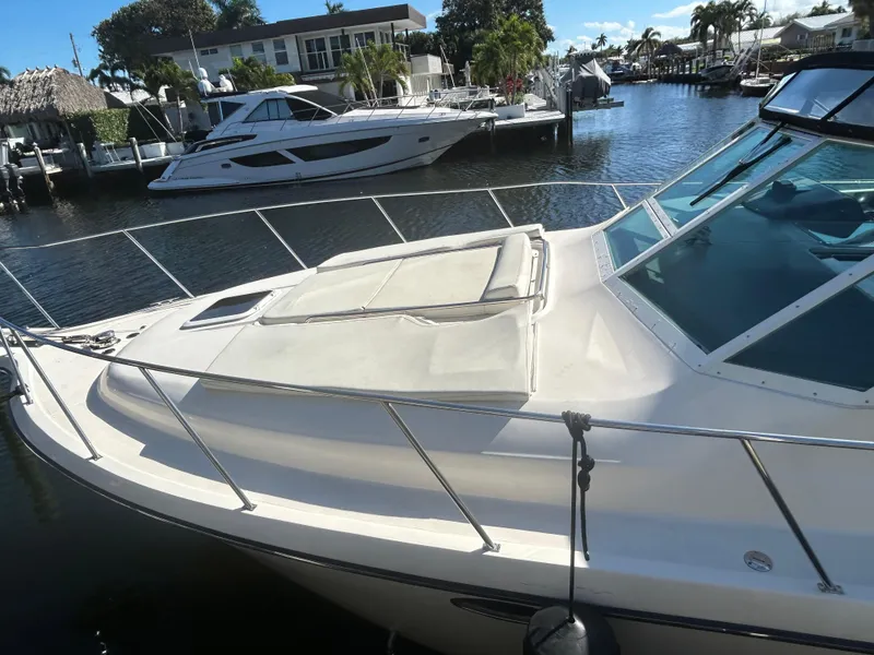 Slide: The Image of 1998 Tiara Yachts 3500 Express docked in a sunny marina setting. - 13