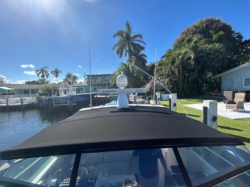 Slide: The Image of 1998 Tiara Yachts 3500 Express docked, sunny day, palm trees, waterfront view. - 22