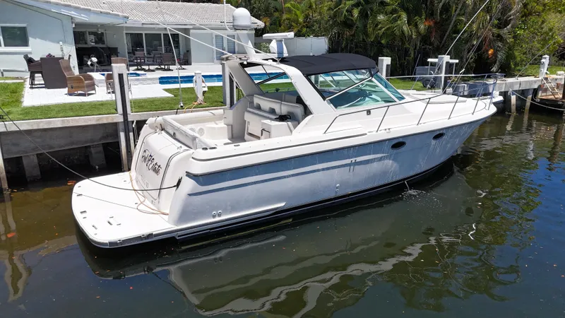 Slide: The Image of 1998 Tiara Yachts 3500 Express docked by a waterfront home. - 6