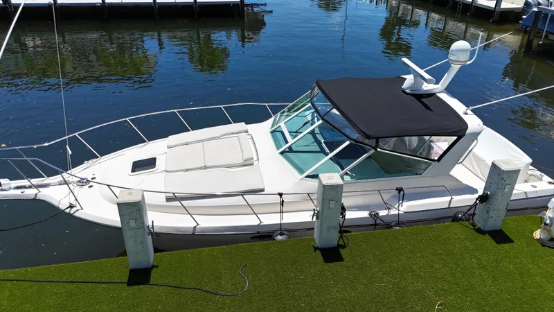 Slide: The Image of 1998 Tiara Yachts 3500 Express docked, featuring sleek design and black canopy. - 9