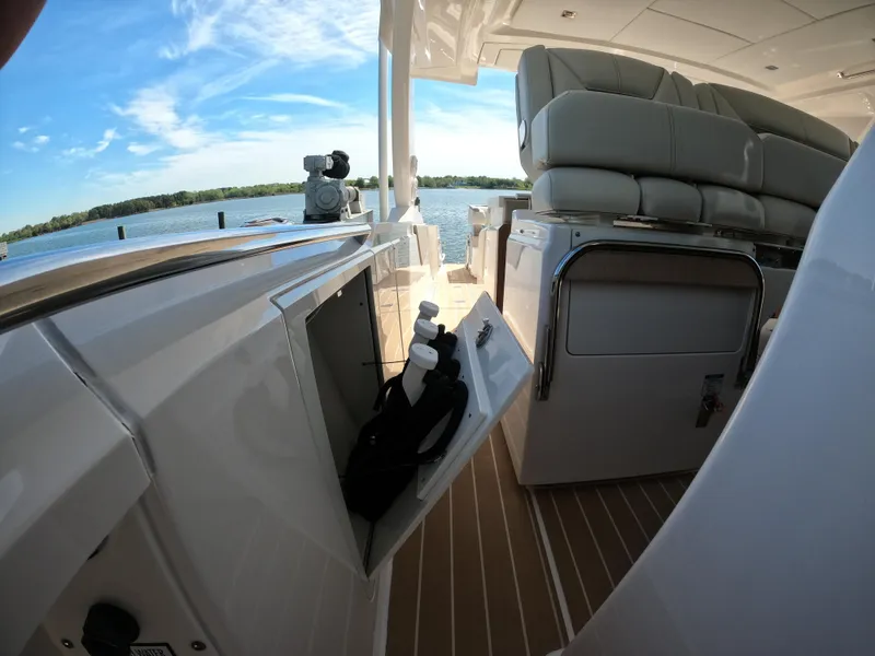Slide: The Image of 2024 Tiara Yachts 43 LS interior with seating and storage, overlooking serene waters. - 16