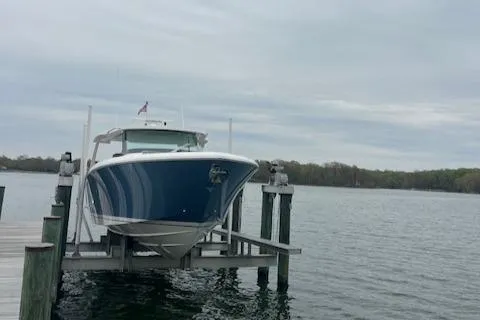 Slide: The Image of 2024 Tiara Yachts 43 LS on dock, blue hull, calm waters, overcast sky. - 2