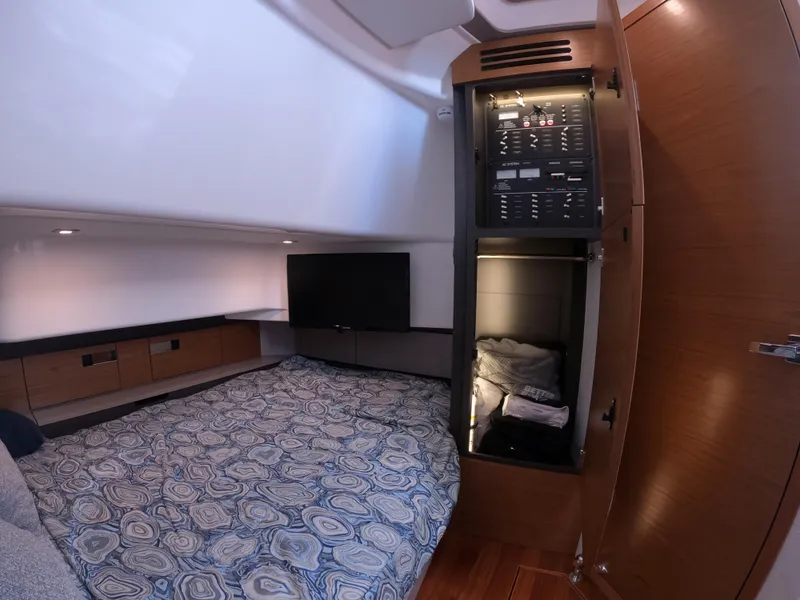 Slide: The Image of 2024 Tiara Yachts 43 LS cabin interior with bed, TV, and control panel. - 20