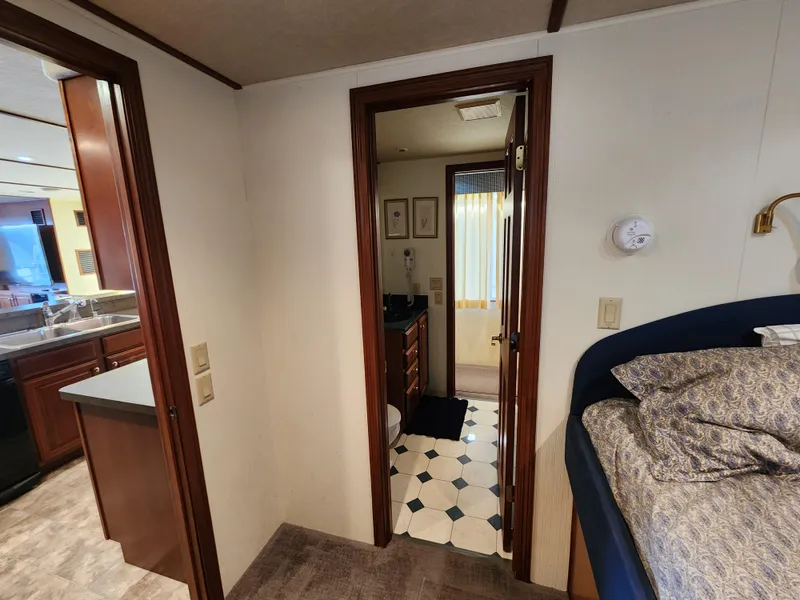 Slide: The Image of 2004 Skipperliner Inn Conspicuous Share interior with bedroom, bathroom, and kitchen view. - 11