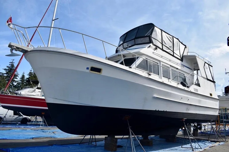 The Image of 1984 Ponderosa 42 yacht on dry dock, showcasing its sleek design and spacious upper deck. - 0