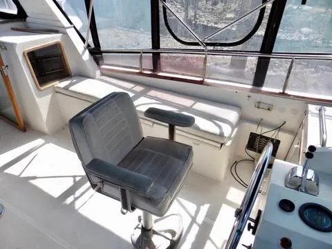Slide: The Image of 1984 Ponderosa 42 boat interior with captain's chair and cushioned seating. - 17
