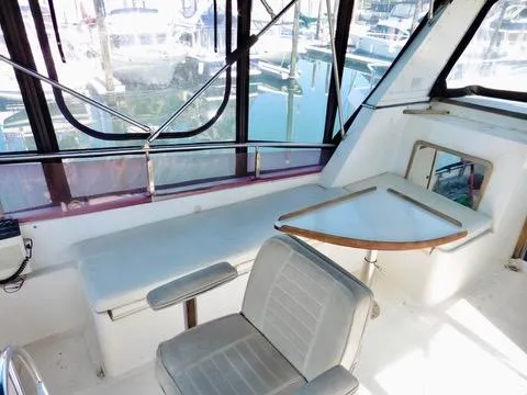 Slide: The Image of Interior of 1984 Ponderosa 42 boat with seating and table, marina view outside. - 18