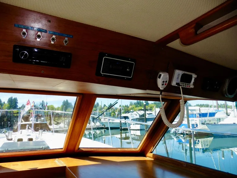 Slide: The Image of Interior view of 1984 Ponderosa 42 boat, showcasing control panel and marina through windows. - 28