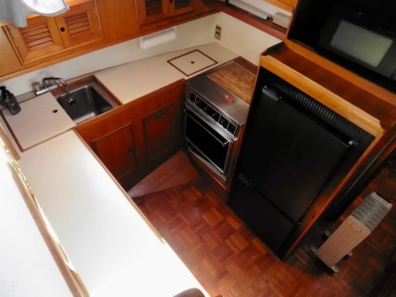 Slide: The Image of 1984 Ponderosa 42 yacht kitchen with wood cabinetry, sink, stove, and refrigerator. - 34
