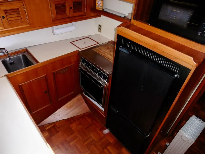 Slide: The Image of 1984 Ponderosa 42 yacht kitchen with wood cabinetry, sink, stove, and refrigerator. - 35