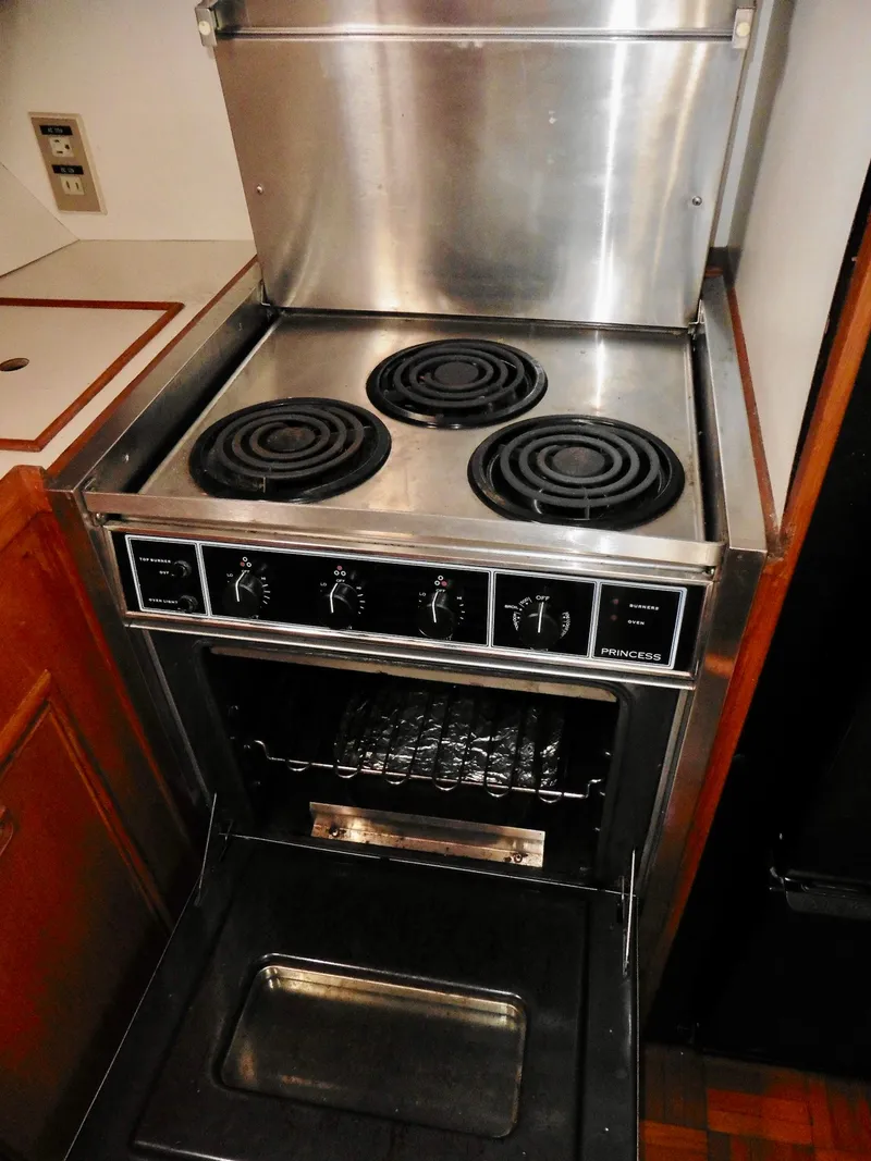 Slide: The Image of Vintage 1984 Ponderosa 42 stove with three burners and open oven door. - 40