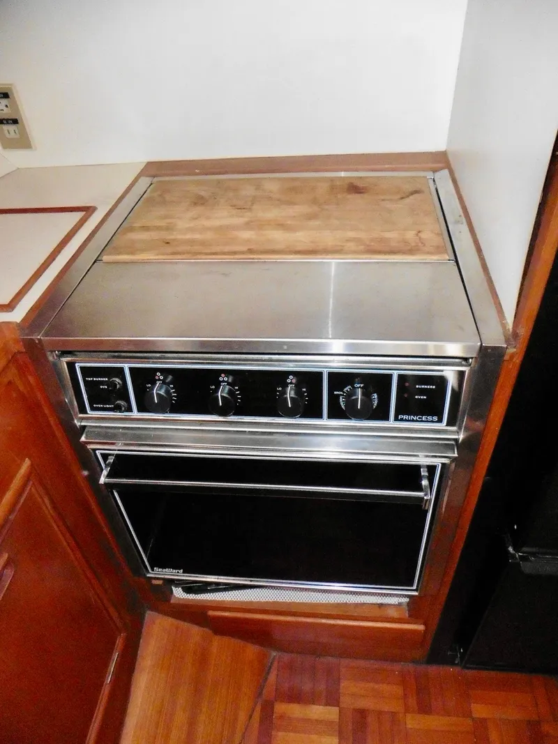 Slide: The Image of 1984 Ponderosa 42 stove with wooden cover, stainless steel finish, and control knobs. - 41