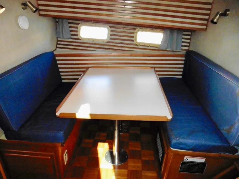 Slide: The Image of 1984 Ponderosa 42 yacht interior with blue seating and wooden accents. - 42
