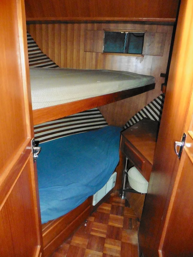 Slide: The Image of Cozy cabin interior of 1984 Ponderosa 42 yacht with wooden bunk beds and small desk. - 43