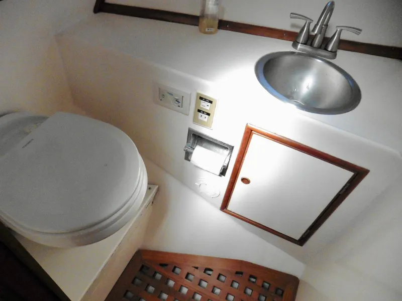 Slide: The Image of Compact bathroom in 1984 Ponderosa 42 boat with sink, toilet, and storage cabinet. - 48