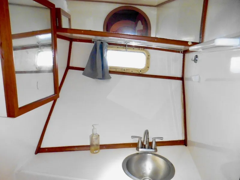 Slide: The Image of 1984 Ponderosa 42 yacht bathroom with sink, mirror, and porthole window. - 49