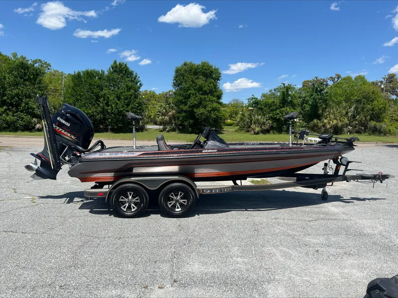 Slide: The Image of 2019 Skeeter ZX225 bass boat on trailer, parked outdoors under a clear blue sky. - 1