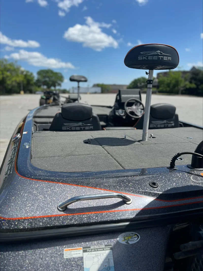 Slide: The Image of 2019 Skeeter ZX225 boat with sleek design, parked under a clear blue sky. - 10