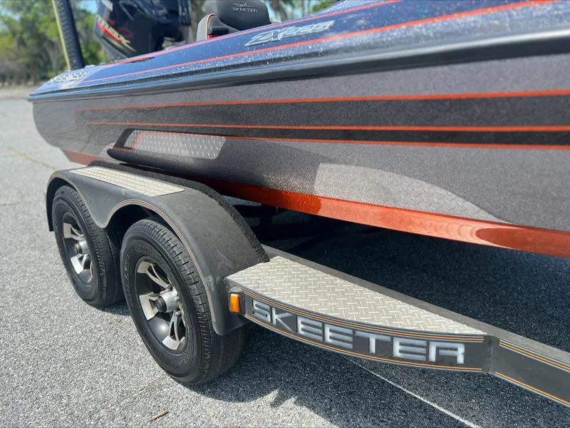 Slide: The Image of 2019 Skeeter ZX225 boat on trailer with dual wheels and sleek design. - 2