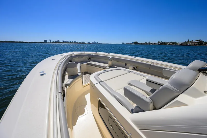 Slide: The Image of 2023 Scout 355 LXF boat on calm water with city skyline in background. - 13