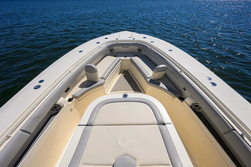 Slide: The Image of 2023 Scout 355 LXF boat bow with seating, on calm blue water. - 14